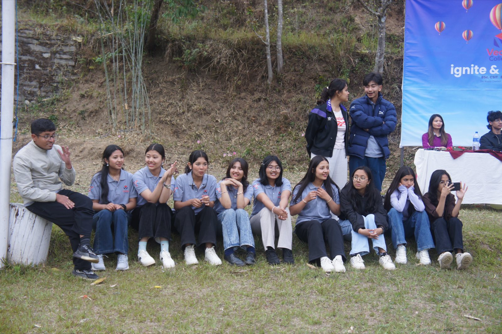 Students watching the programme from the grass at a college event