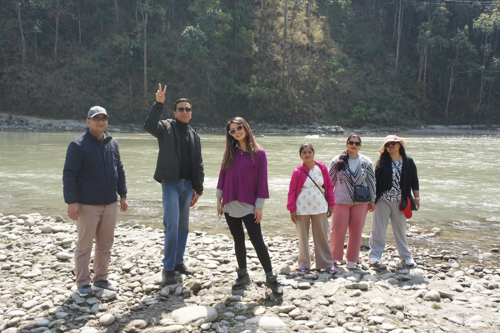 A group standing on the riverbank during a college trip